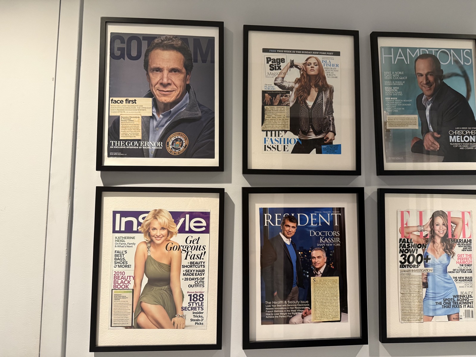 A wall of framed magazine features at Berenice, including Gotham, Page Six Magazine, Hamptons, InStyle, Resident and ELLE